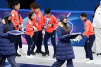 表彰台（手前）から下りた後、靴のブレードの状態を確認する（奥右から）坂本花織、鍵山優真ら（共同）