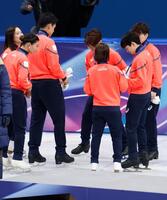 表彰台（手前）から下りた後、靴のブレードの状態を確認する森田真沙也（奥）＝共同