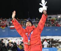 銅メダルを胸に歓声に応える二階堂蓮＝プレダッツォ・ジャンプ競技場（撮影・吉澤敬太）