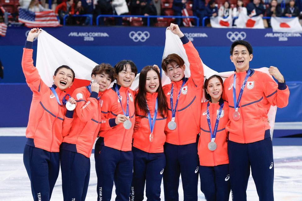 　銀メダルを獲得し、日の丸を掲げる（左から）坂本花織、佐藤駿、鍵山優真、吉田唄菜、森田真沙也、三浦璃来、木原龍一（共同）
