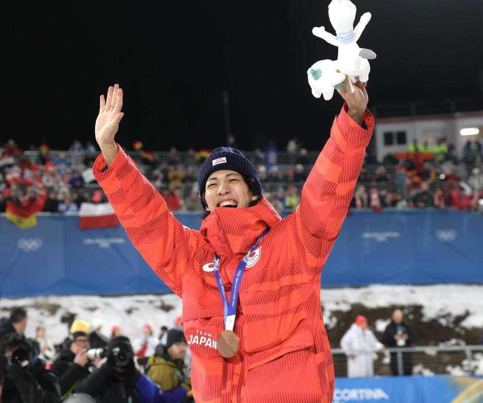 銅メダルを胸に歓声に応える二階堂蓮＝プレダッツォ・ジャンプ競技場（撮影・吉澤敬太）