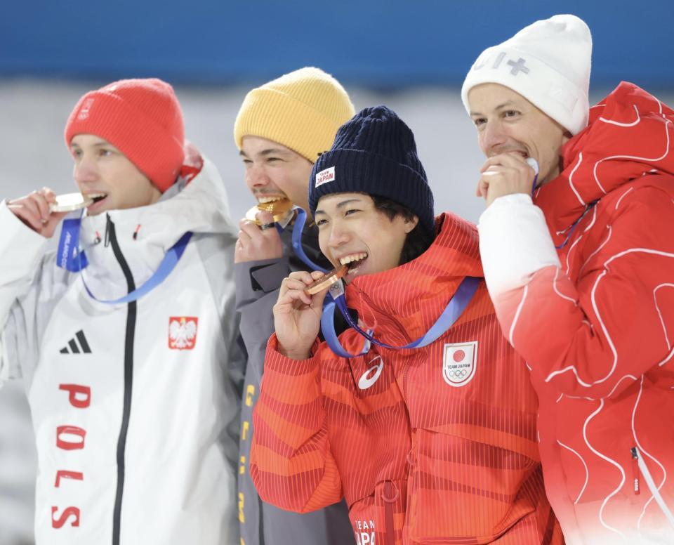 銅メダルを笑顔でかじる二階堂蓮（中央）＝プレダッツォ・ジャンプ競技場（撮影・吉澤敬太）