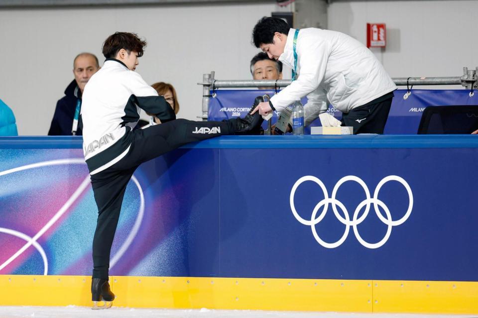 練習中に日下匡力コーチ（右）に靴のブレードを磨いてもらうフィギュアスケート男子の佐藤駿＝９日、イタリア・ミラノ（共同）