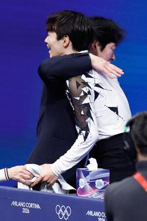 男子ＳＰの演技を終え、父の正和コーチ（奥）と抱き合う鍵山優真（共同）