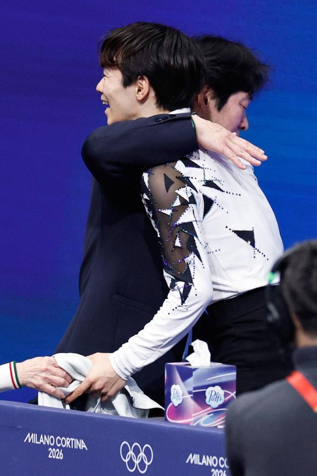 男子ＳＰの演技を終え、父の正和コーチ（奥）と抱き合う鍵山優真（共同）