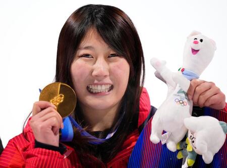 女子ビッグエアで優勝し、笑顔で金メダルを掲げる村瀬心椛＝９日（共同）