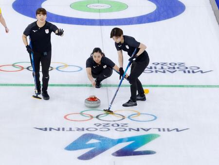 日本－スウェーデン　第２エンド、ショットを放つ近江谷。左は小谷、右は小野寺＝コルティナダンペッツォ（共同）