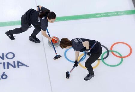 日本－スウェーデン　第８エンド、スイープする近江谷（左）と小野寺＝コルティナダンペッツォ（共同）