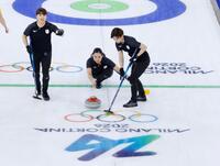 日本－スウェーデン　第１エンド、ショットを放つ近江谷。左は小谷、右は小野寺＝コルティナダンペッツォ（共同）