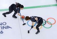日本－スウェーデン　第８エンド、スイープする近江谷（左）と小野寺＝コルティナダンペッツォ（共同）