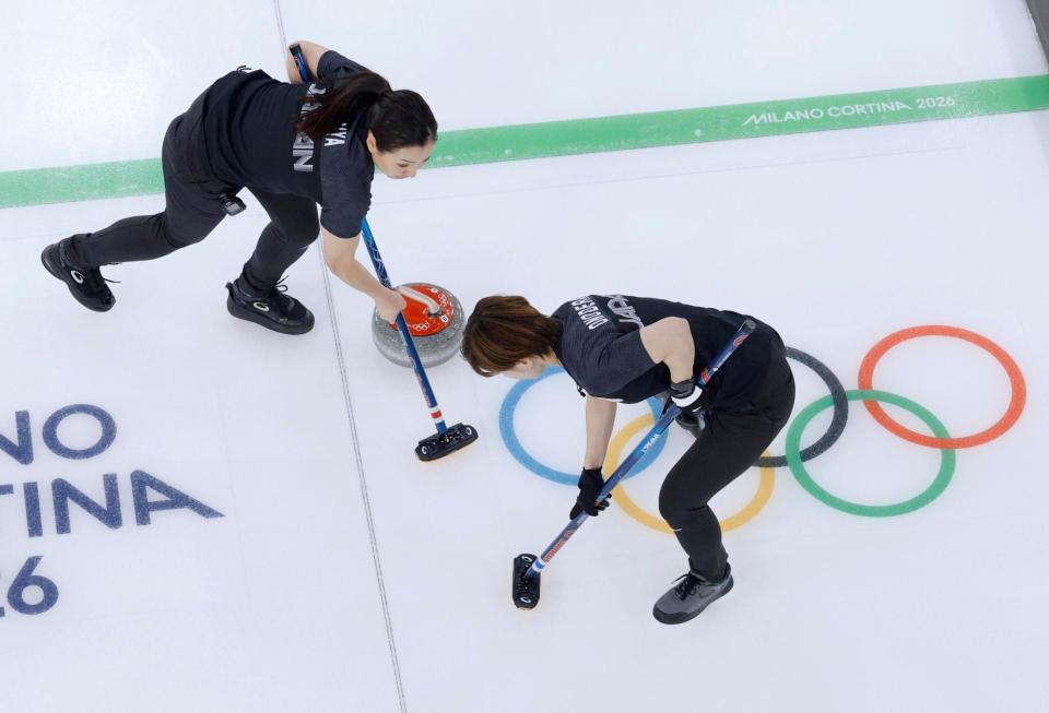 日本－スウェーデン　第８エンド、スイープする近江谷（左）と小野寺＝コルティナダンペッツォ（共同）