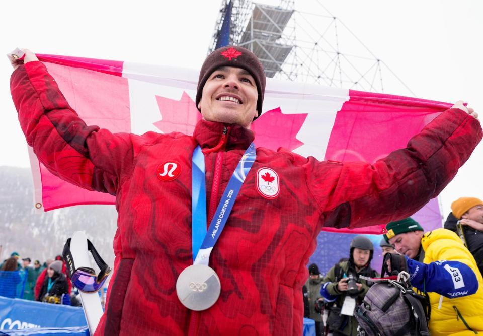 男子モーグルで銀メダルを獲得し、笑顔で国旗を掲げるミカエル・キングズベリー＝リビーニョ（共同）