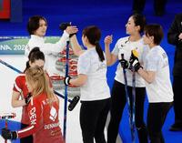 日本－デンマーク　第８エンドで同点に追い付き、タッチを交わす（奥左から）吉村、小谷、近江谷、小野寺＝コルティナダンペッツォ（共同）