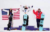 女子ハーフパイプで銅メダルを獲得し、日の丸を掲げる小野光希。中央は金メダルの崔ガオン、左は銀メダルのクロイ・キム＝リビーニョ（共同）