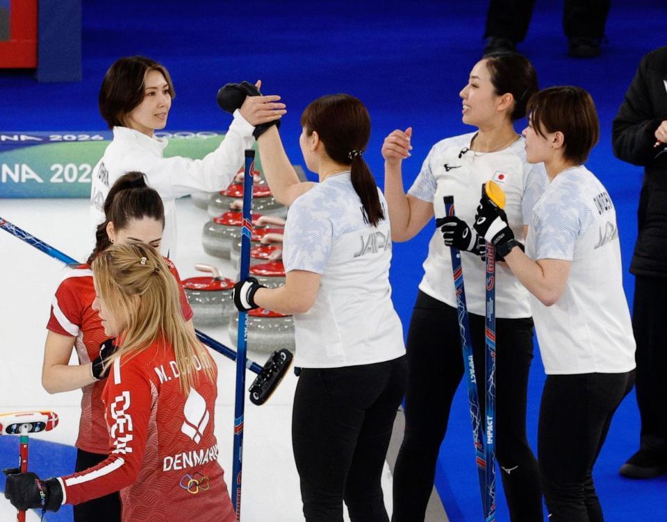 日本－デンマーク　第８エンドで同点に追い付き、タッチを交わす（奥左から）吉村、小谷、近江谷、小野寺＝コルティナダンペッツォ（共同）