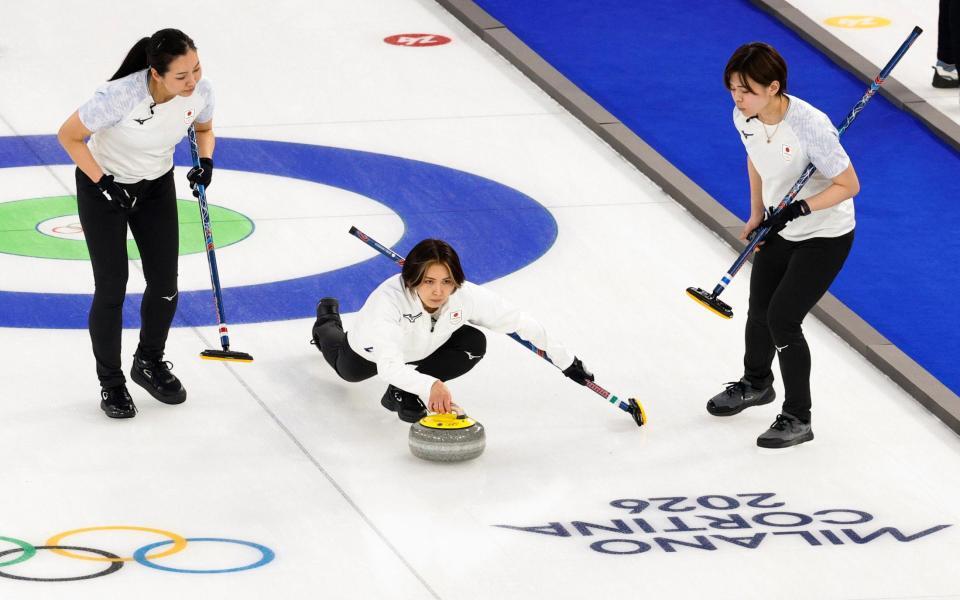 日本－デンマーク　第10エンド、ショットを放つ吉村（中央）。同点に追い付き延長となる＝コルティナダンペッツォ（共同）