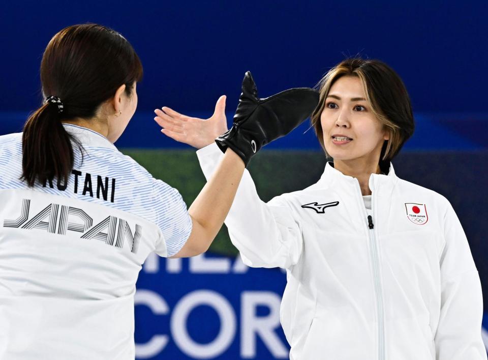 日本－デンマーク　第10エンドで同点に追い付き、小谷（左）とタッチを交わす吉村＝コルティナダンペッツォ（共同）