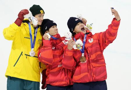 　男子ハーフパイプで金メダルを獲得し、表彰台で記念撮影する戸塚優斗（中央）。右は銅メダルの山田琉聖＝リビーニョ（共同）
