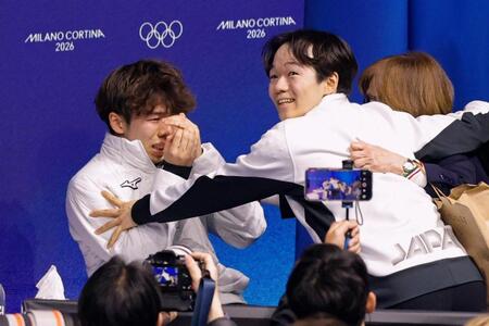 男子で銅メダルを獲得し涙ぐむ佐藤駿（左）を祝福する銀メダルの鍵山優真＝ミラノ（共同）