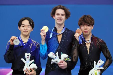 男子の表彰式でメダルを掲げる（左から）銀メダルの鍵山優真、金メダルのミハイル・シャイドロフ、銅メダルの佐藤駿