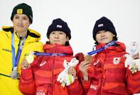 　男子ハーフパイプの表彰式で金メダルを掲げる戸塚優斗（中央）。右は銅の山田琉聖＝リビーニョ（共同）