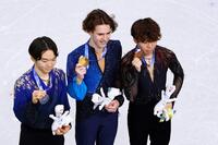男子で銀メダルを獲得した鍵山優真（左）と銅メダルの佐藤駿。中央は金メダルのミハイル・シャイドロフ＝ミラノ（共同）