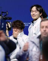 男子で銅メダル獲得が決まり、涙ぐむ佐藤駿。右は銀メダルの鍵山優真＝ミラノ（共同）