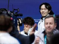 男子で銅メダル獲得が決まり、涙ぐむ佐藤駿。右は銀メダルの鍵山優真＝ミラノ（共同）