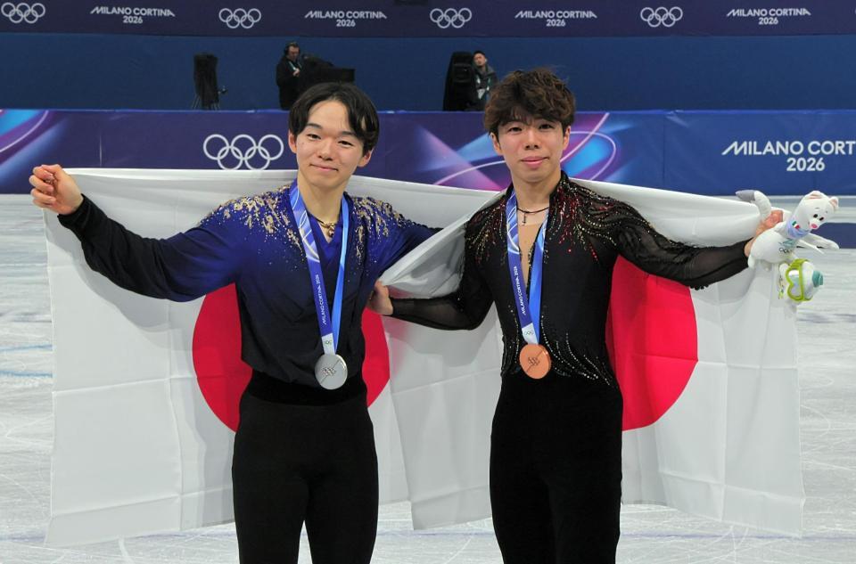 日の丸を掲げる銀メダルの鍵山優真（左）と銅メダルの佐藤駿
