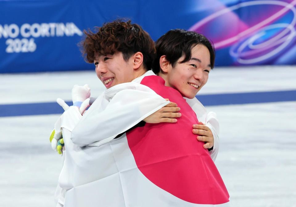 抱き合って喜ぶ銀メダルの鍵山優真（右）と銅メダルの佐藤駿
