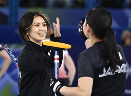 　日本－米国　第４エンドで２点を奪い、近江谷（右）とタッチを交わす吉村＝コルティナダンペッツォ（共同）