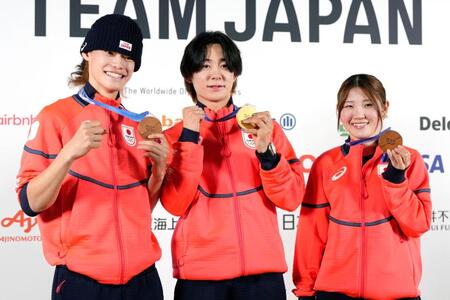 記者会見でメダルを掲げるスノーボード・ハーフパイプの（左から）山田琉聖、戸塚優斗、小野光希＝15日、イタリア・ミラノ（共同）