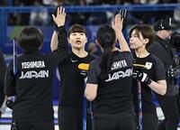 　日本－米国　第４エンドで２点を奪い、タッチを交わす小谷（左から２人目）ら＝コルティナダンペッツォ（共同）