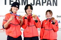 記者会見でメダルを掲げるスノーボード・ハーフパイプの（左から）山田琉聖、戸塚優斗、小野光希＝15日、イタリア・ミラノ（共同）