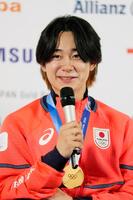 金メダルを胸に記者会見するスノーボード男子ハーフパイプの戸塚優斗＝15日、イタリア・ミラノ（共同）