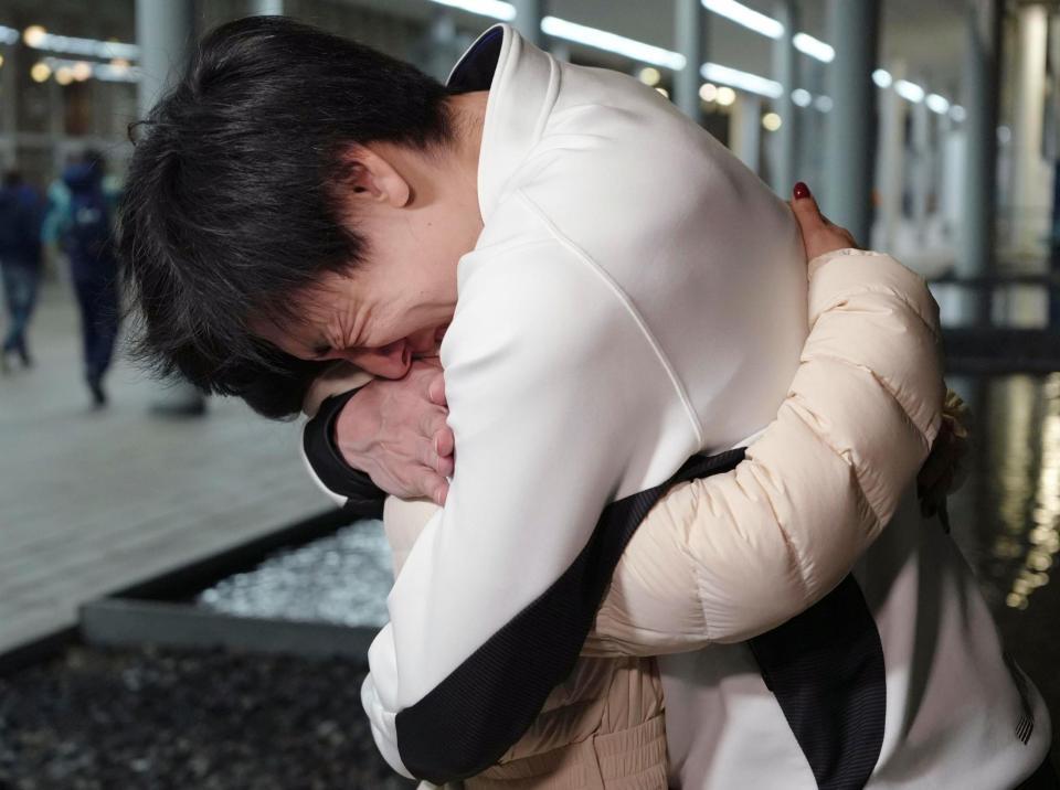 スピードスケート男子５００メートルのレース後、妻の吉田夕梨花を抱きしめる新濱立也（共同）