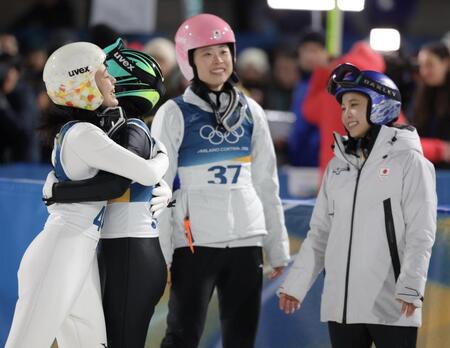 飛躍を終え伊藤有希と抱き合う丸山希（左）。右から高梨沙羅、勢藤優花＝プレダッツォ・ジャンプ競技場（撮影・吉澤敬太）