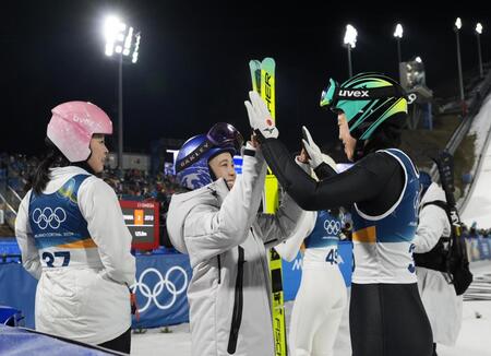 女子個人ラージヒルで日本勢の飛躍が終わり、タッチを交わす高梨沙羅（中央）と伊藤有希（右）＝プレダッツォ（共同）