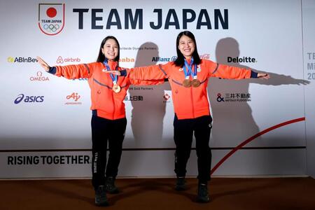 メダルを胸にテレマークのポーズをとるノルディックスキー・ジャンプ女子の高梨沙羅（左）と丸山希（共同）