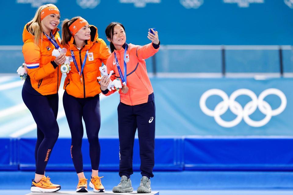女子５００メートルで金メダルのフェムケ・コク（中央）、銀メダルのユタ・レールダム（左）と自撮りする銅メダルの高木美帆＝ミラノ（共同）