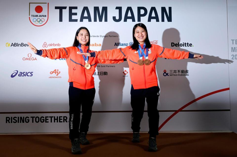 メダルを胸にテレマークのポーズをとるノルディックスキー・ジャンプ女子の高梨沙羅（左）と丸山希（共同）