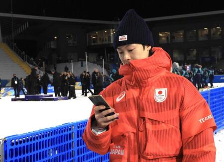 表彰式後、スタッフが記念撮影する表彰台を背に引き揚げる小林陵侑＝プレダッツォ・ジャンプ競技場（撮影・吉澤敬太）