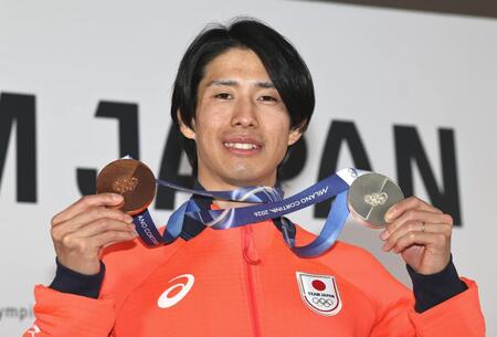 笑顔でメダルを掲げる堀島行真＝ミラノ