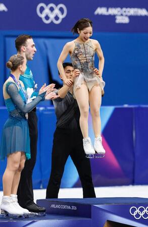 金メダルの表彰台に三浦璃来を乗せる木原龍一（奥）＝共同