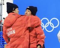 最後の飛躍が出来ずにジャンプ台から戻ってきた小林陵侑（左）と抱き合う二階堂蓮＝プレダッツォ・ジャンプ競技場（撮影・吉澤敬太）