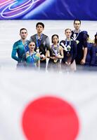 ペアで金メダルを獲得し、掲揚される日の丸を見つめる三浦璃来（中央右）、木原龍一（同左）組（共同）