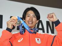 笑顔でメダルを掲げる堀島行真＝ミラノ