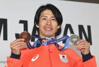 笑顔でメダルを掲げる堀島行真＝ミラノ