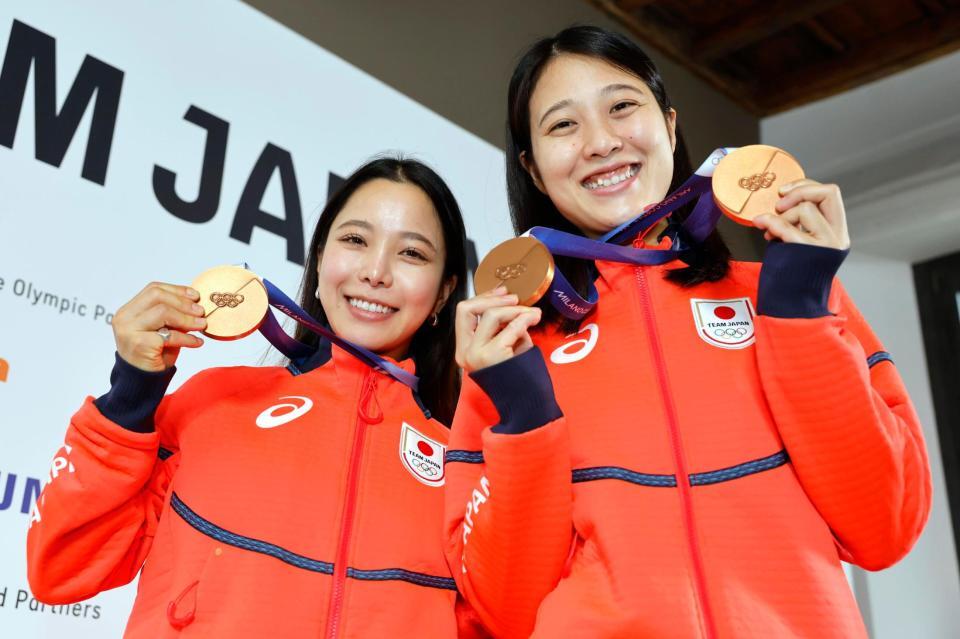 　記者会見でメダルを掲げるノルディックスキー・ジャンプ女子の高梨沙羅（左）と丸山希（共同）