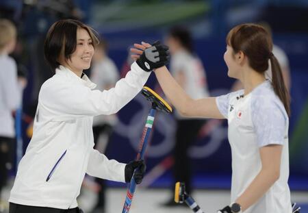 小林未奈（右）と笑顔でタッチする吉村紗也香＝コルティナ・カーリング・オリンピック・スタジアム（撮影・吉澤敬太）